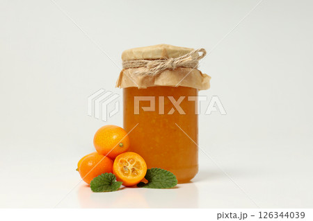 Fresh kumquat fruits and glass jar with jam on white background Fresh kumquat fruits and glass jar with jam on white background 126344039