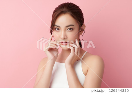 A beautiful young Asian woman with clean, fresh skin against a pink background. Skincare, facial treatment, cosmetology, beauty, and spa. An elegant portrait of an Asian woman. A beautiful young Asian woman with clean, fresh skin against a pink background. Skincare, facial treatment, cosmetology, beauty, and spa. An elegant portrait of an Asian woman. 126344830