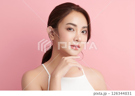 A beautiful young Asian woman with clean, fresh skin against a pink background. Skincare, facial treatment, cosmetology, beauty, and spa. An elegant portrait of an Asian woman. A beautiful young Asian woman with clean, fresh skin against a pink background. Skincare, facial treatment, cosmetology, beauty, and spa. An elegant portrait of an Asian woman. 126344831