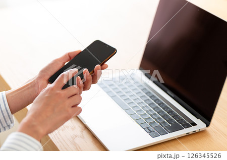 スマホを持つミドル女性の手元 126345526
