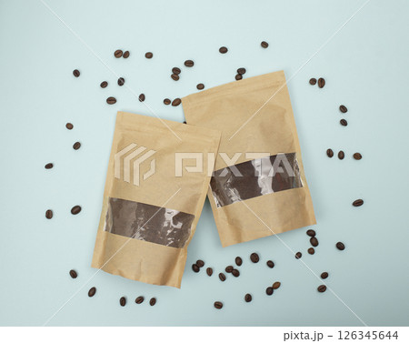 Paper eco bags with freshly ground coffee and coffee beans on a blue background. Top view. Flat lay. 126345644