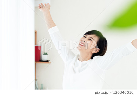 窓辺で伸びをする女性 126346016