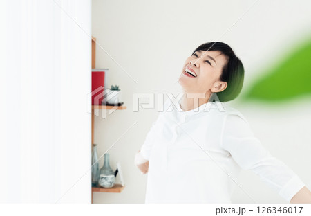 窓辺で伸びをする女性 126346017