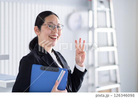 笑顔でワンポイントサインをする女性建築士 126346098