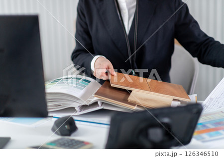 建築資料を確認する女性社員の手元 126346510