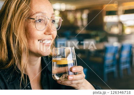 Happy Woman Drinking Water in Cafe, Healthy Lifestyle and Refreshment, Natural Light Close-Up Happy Woman Drinking Water in Cafe, Healthy Lifestyle and Refreshment, Natural Light Close-Up 126346718