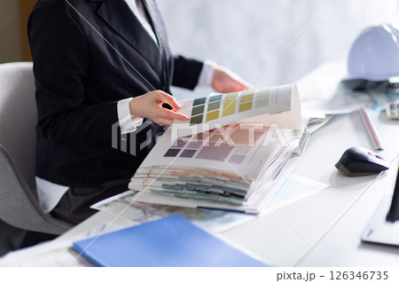 壁紙サンプルをチェックする女性の手元 126346735
