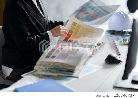 壁紙サンプルをチェックする女性の手元 126346737