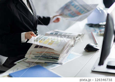 壁紙サンプルをチェックする女性の手元 126346738