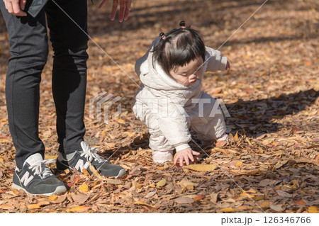【落ち葉で敷き詰められた冬の公園で遊ぶ1歳児　立つ】 126346766