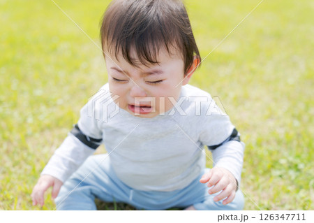 芝生に座って泣く赤ちゃん 126347711