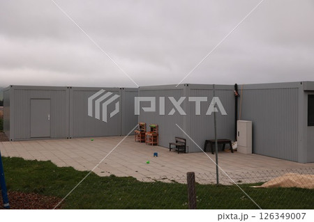 Grey building with a door and a window Grey building with a door and a window 126349007