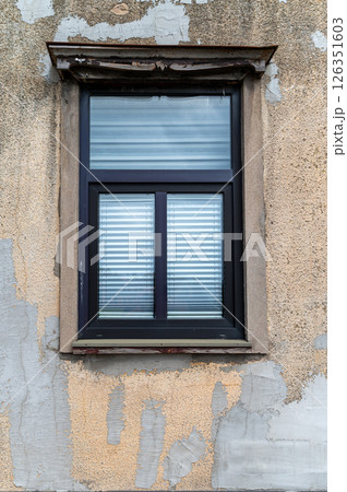 Close-up view of a vintage window against a peeling wall in a quaint building exterior Close-up view of a vintage window against a peeling wall in a quaint building exterior 126351603