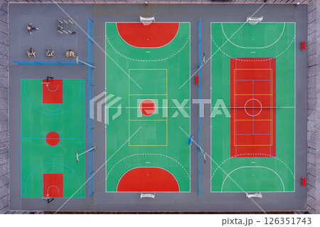 Aerial view of vibrant multi-sport courts in urban area with basketball and tennis sections Aerial view of vibrant multi-sport courts in urban area with basketball and tennis sections 126351743