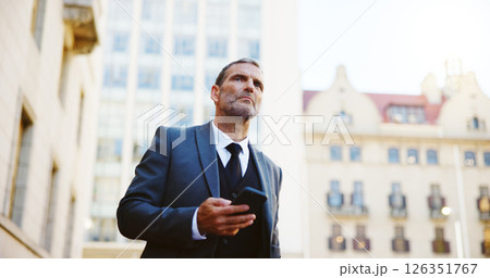 Businessman, phone and waiting in city for taxi, cab ride or transportation to travel. Man, employee or mobile smartphone with app or lift for local commute, destination or location in an urban town 126351767