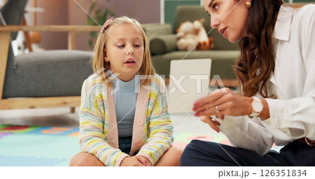 Woman, girl and psychology with card for evaluation with talk, guide and emotional assessment on floor. Therapy, child and paper with consultation, test and exam for help with mental health at clinic 126351834