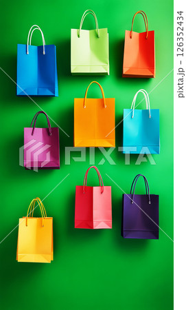 Bright and colorful shopping bags set against a green background, presenting a lively and fashionable design, perfect for retail marketing and fashion-related promotional materials 126352434
