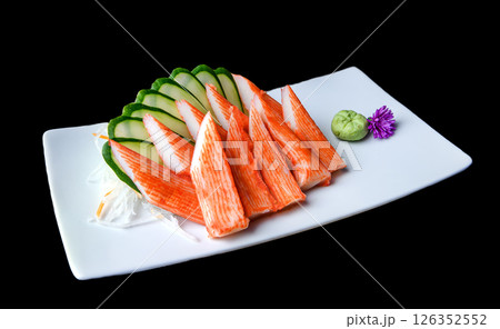 Imitation crab sashimi with cucumber slices and wasabi on white plate 126352552