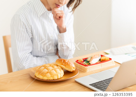 会社のデスクでランチに悩むミドル女性 126353395