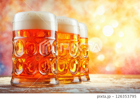 Enjoying foamy beer in large glass goblets during Oktoberfest celebration in a festive atmosphere 126353795