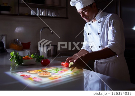 Chef engages with holographic recipe book while preparing meals in a modern kitchen 126354035