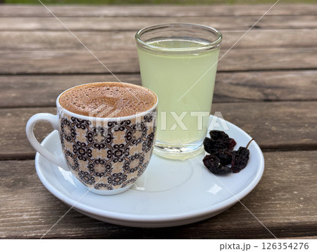 Traditional coffee service in Turkey with citrus water and dried fruits on wooden table 126354276