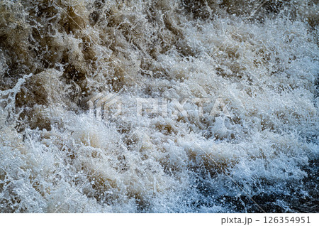 close up of flowing water, rapid water splashes of an white water river or stream, bubbly water 126354951