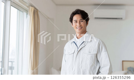 室内で笑顔を見せる作業着の男性 126355296