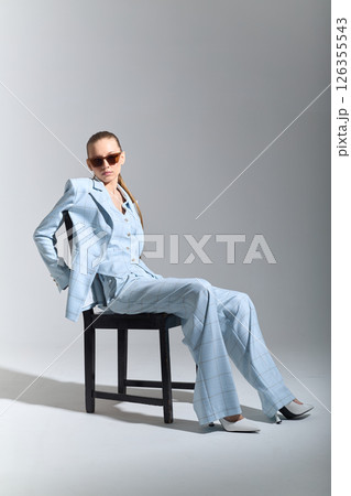 High fashion portrait of young confident female model in blue three-piece suit. Monochrome blue outfit High fashion portrait of young confident female model in blue three-piece suit. Monochrome blue outfit 126355543