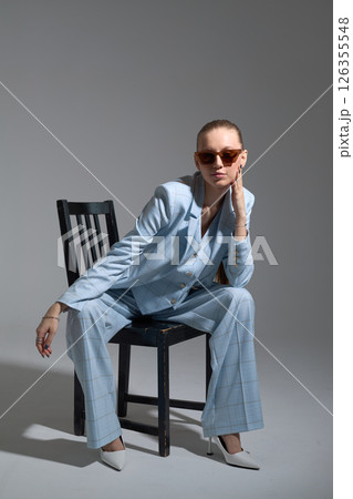 High fashion portrait of young confident female model in blue three-piece suit. Monochrome blue outfit High fashion portrait of young confident female model in blue three-piece suit. Monochrome blue outfit 126355548
