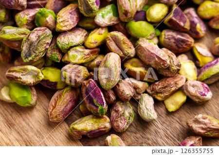 Shelled pistachio nuts on a wooden surface. 126355755