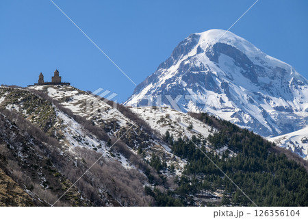Gergeti Trinity Church and Mount Kazbek near the village of Stepantsminda in the Caucasus mountains in Georgia 126356104