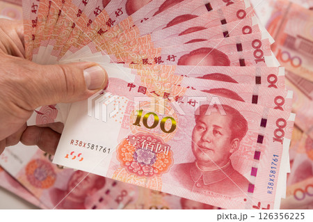 Big pile of different Chinese yuan banknotes 100 in hand. Chinese paper currency Yuan renminbi banknotes and coins. Copy space. Close up. 126356225