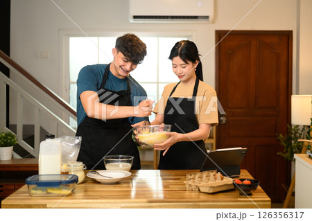 Romantic couple couple prepares breakfast in warm kitchen Romantic couple couple prepares breakfast in warm kitchen 126356317