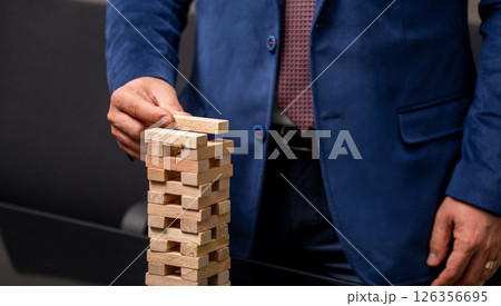Businessman placing wooden block on tower.Growth and strategy concept. Businessman placing wooden block on tower.Growth and strategy concept. 126356695