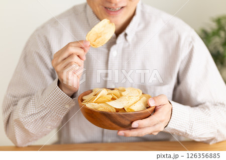 ポテトチップスを食べるミドル男性 126356885