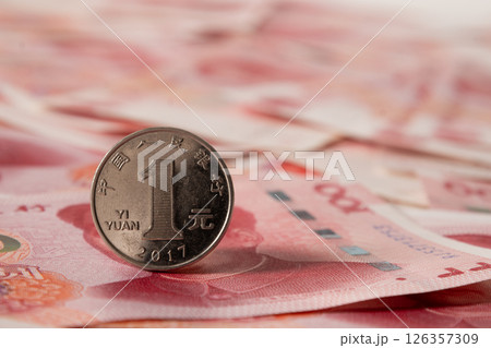 Single Chinese coin stands upright over banknote. Close up. Single Chinese coin stands upright over banknote. Close up. 126357309