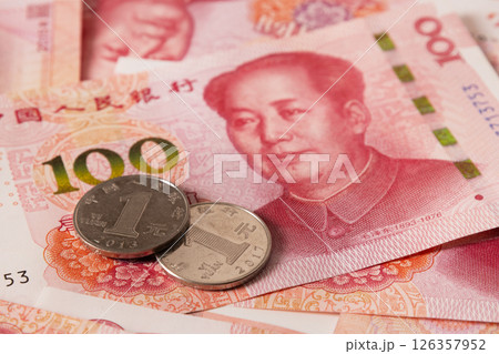 Chinese coins lying on 100 banknotes. Chinese paper currency Yuan renminbi banknotes. Cash. Close up. 126357952