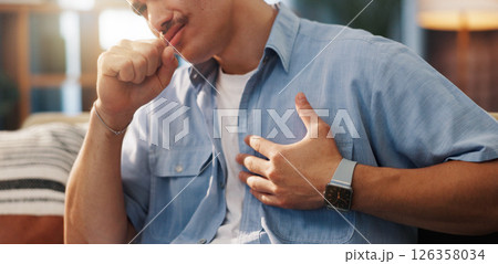 Man, cough and chest pain with illness for asthma, influenza or bronchitis on sofa at home. Male person, sick or heart burn with ache or cramp for discomfort, cardiac arrest or symptoms at house 126358034