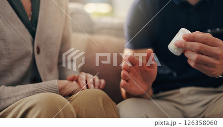 Hands, old woman and caregiver with pills on sofa for illness management, prescription drugs or explain dosage. Homecare, patient and healthcare worker with medication discussion for health treatment 126358060