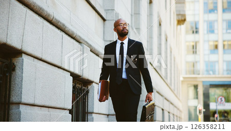 Businessman, lawyer and walking with briefcase in city for corporate travel, law or job opportunity. Man, employee or attorney with folder or bag for court case or legal advice in an urban town 126358211