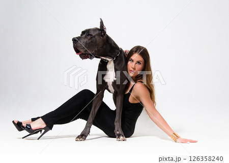 Portrait of beautiful slender model dressed in the black suit with german dogge on a white background 126358240