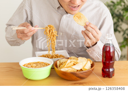 ジャンクフードを暴飲暴食するミドル男性 126358408