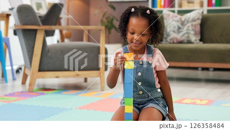 Black girl, block and building with toys for fun activity or playing on floor at therapy office. Kindergarten kid, child or student with shapes for playful learning, fine motor skills or education 126358484