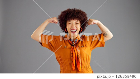 Portrait, flexing arms and woman in studio, smile and power with confident personality on grey background. Face, happy person and model with gesture, space or female empowerment with challenge or win 126358490