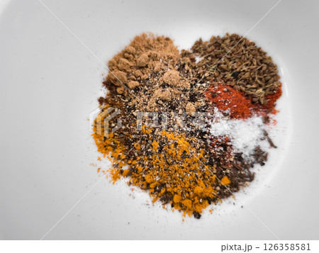 Vibrant spices creating a colorful arrangement heart on a white surface, enhancing culinary creations with rich flavors and aromas background wallpaper copy space 126358581