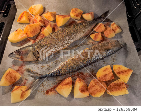 Two mackerel fish with potatoes and spices baking in oven Two mackerel fish with potatoes and spices baking in oven 126358684