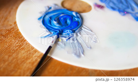 Close-up of a smeared bright acrylic paints on a white plastic palette. 126358974