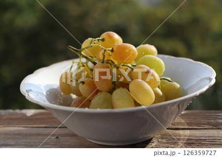 A bunch of amber grapes in a white plate. 126359727