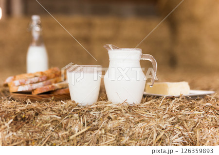 milk in a jug, slices of wheat bread and butter on hay milk in a jug, slices of wheat bread and butter on hay 126359893